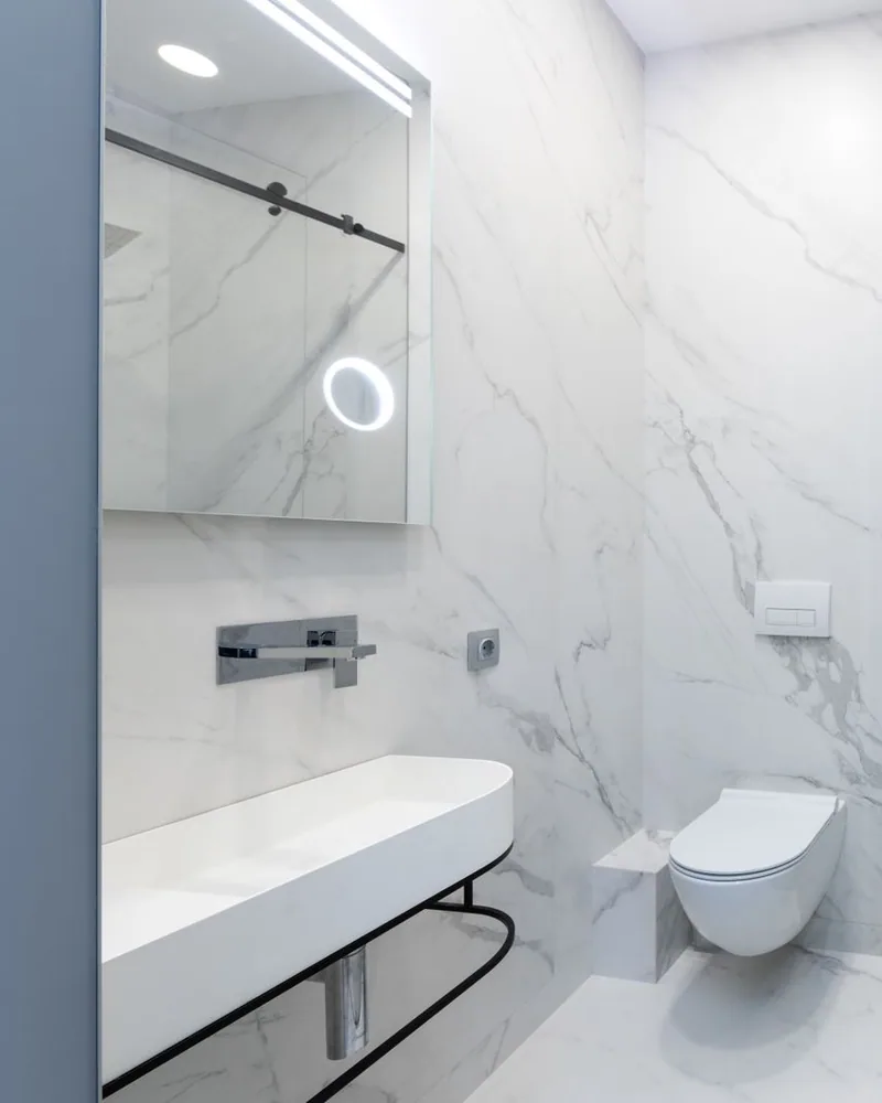 Floor-to-ceiling marble-look shower tile with a glass enclosure